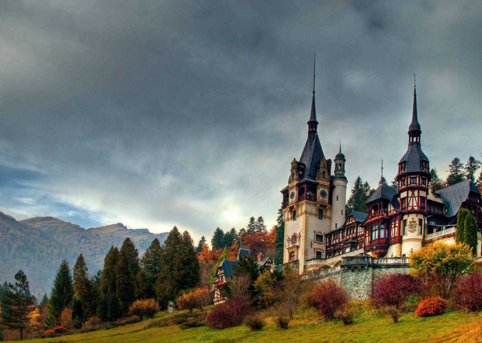 Schloss Peleș in Sinaia im Herbst, mit Türmen und Terrassen, unterhalb des Bucegi-Gebirges