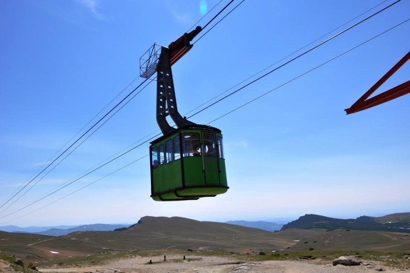 En grønn taubanegondol på kabelen, over Bucegi-platået ved Babele, mot en klar himmel