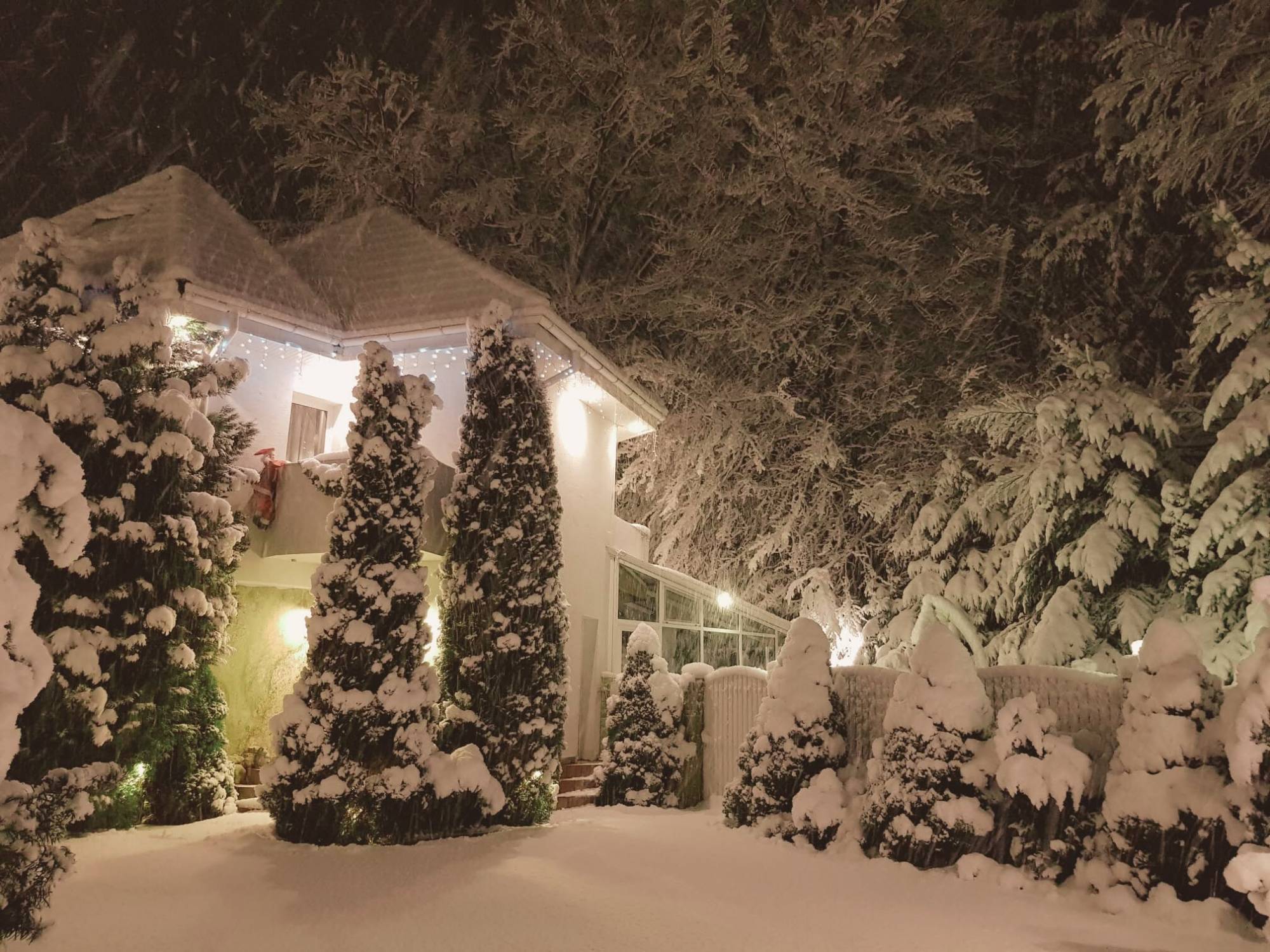 Vilă luminată de Crăciun, noaptea, în timpul ninsorii, cu Moș Crăciun pe balcon, Forest Retreat Villas, Bușteni